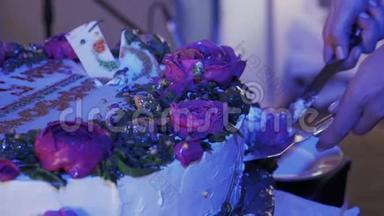 在庆祝活动中，女人用刀切着玫瑰大蛋糕。 <strong>紫光</strong>。